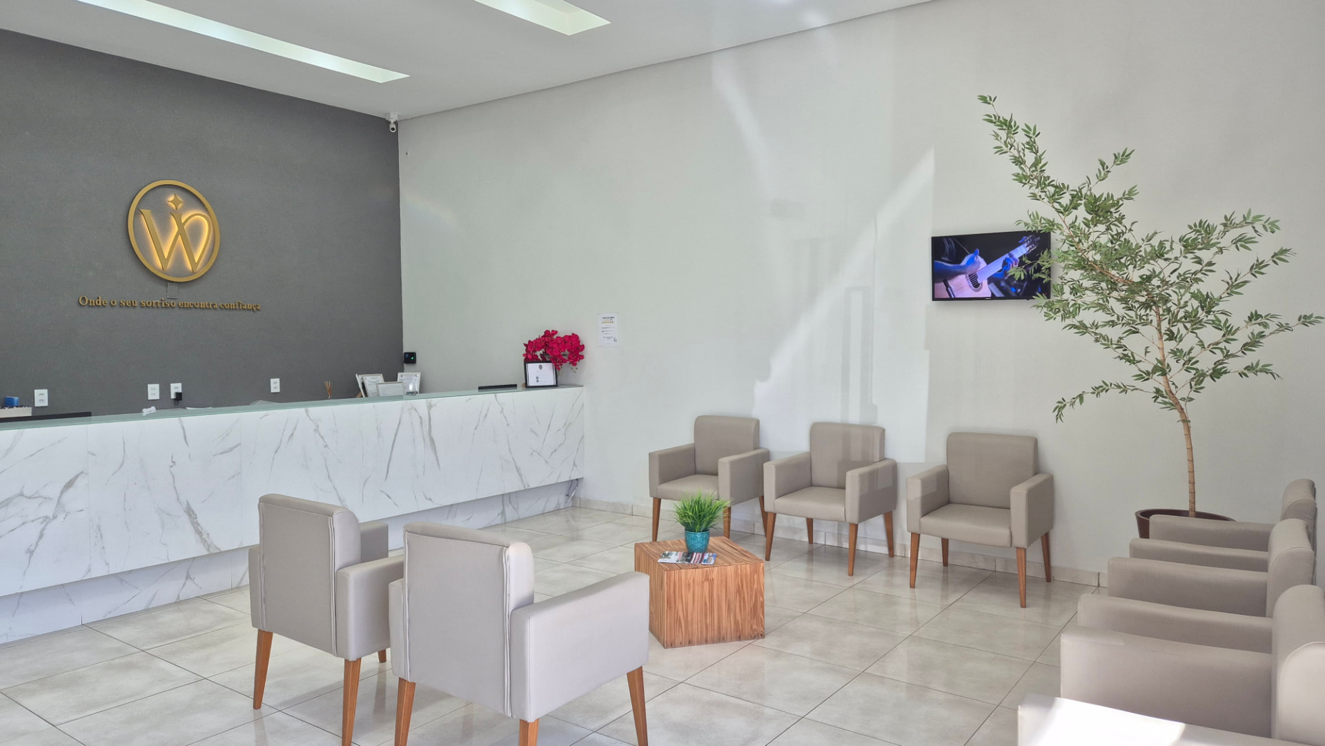 Recepção da West Odontologia com logo dourado na parede